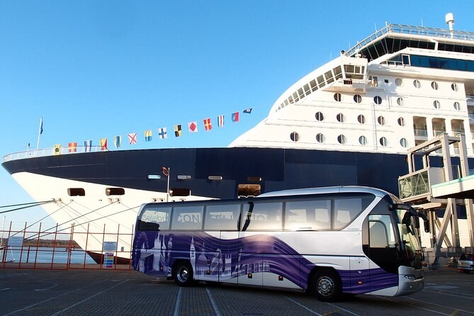 A touring coach waiting on the quay alongside a cruise ship in Southampton