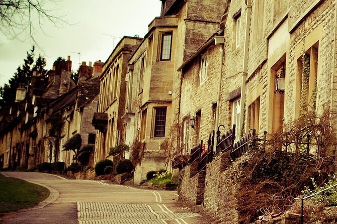 A lane of honey-stone houses climbing through a Cotswolds village