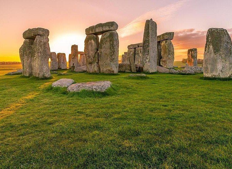 The Stonehenge sarsen circle against a low orange sun